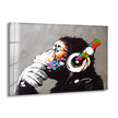 Banksy DJ Monkey Gorilla Thinking Glass Wall Art: A painting of a monkey wearing headphones, meticulously printed on tempered glass for durable, vibrant street art decor.