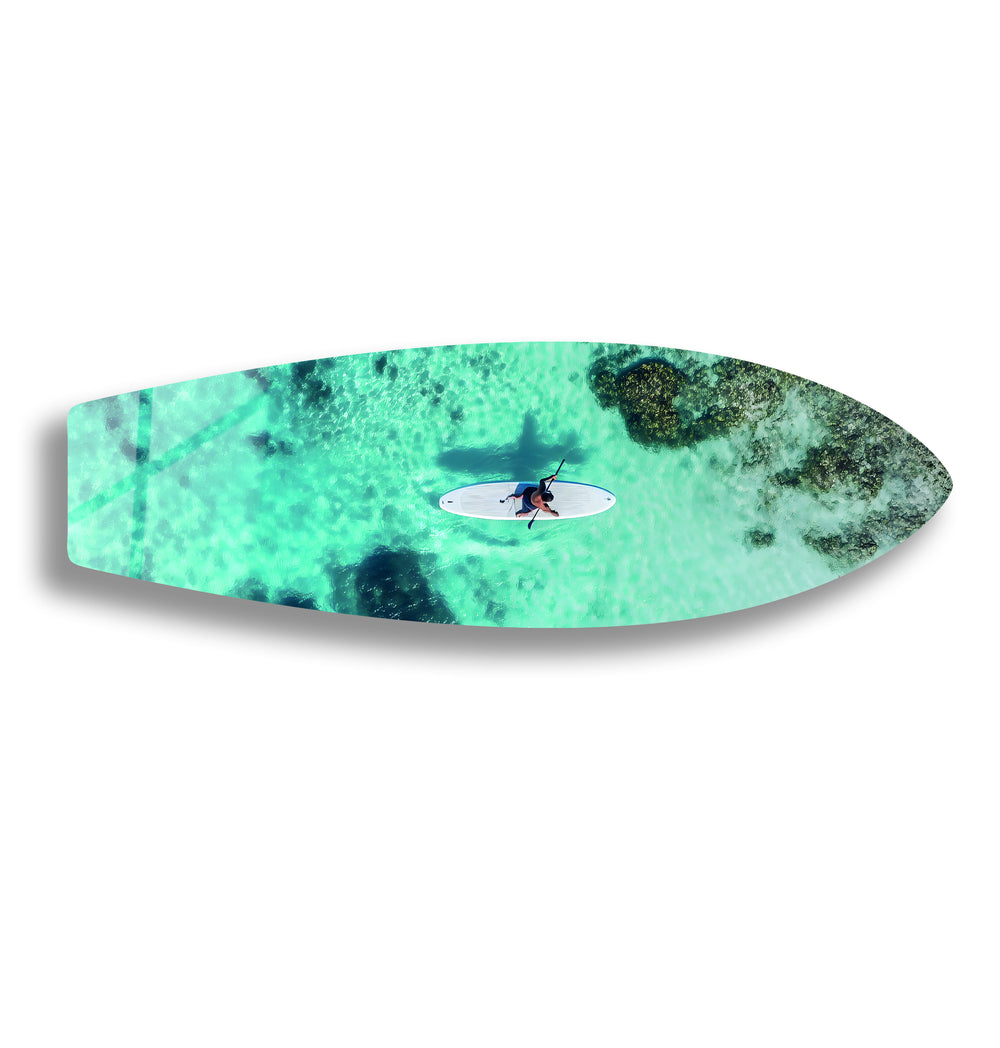 Serene ocean scene with a paddleboarder enjoying the calm, clear waters, perfect for beach-inspired decor.
