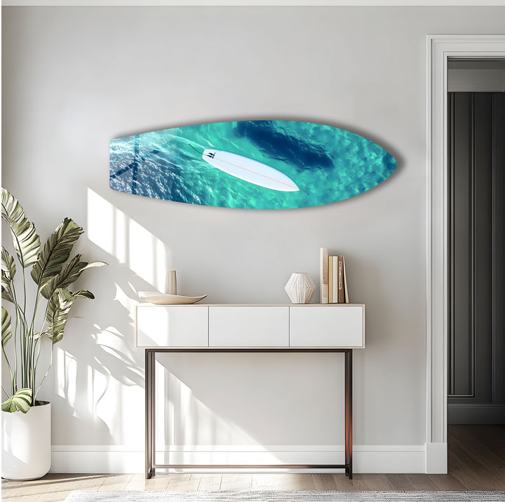 Aerial view of a surfer gliding through serene turquoise waters, captured in high-definition glass art.
