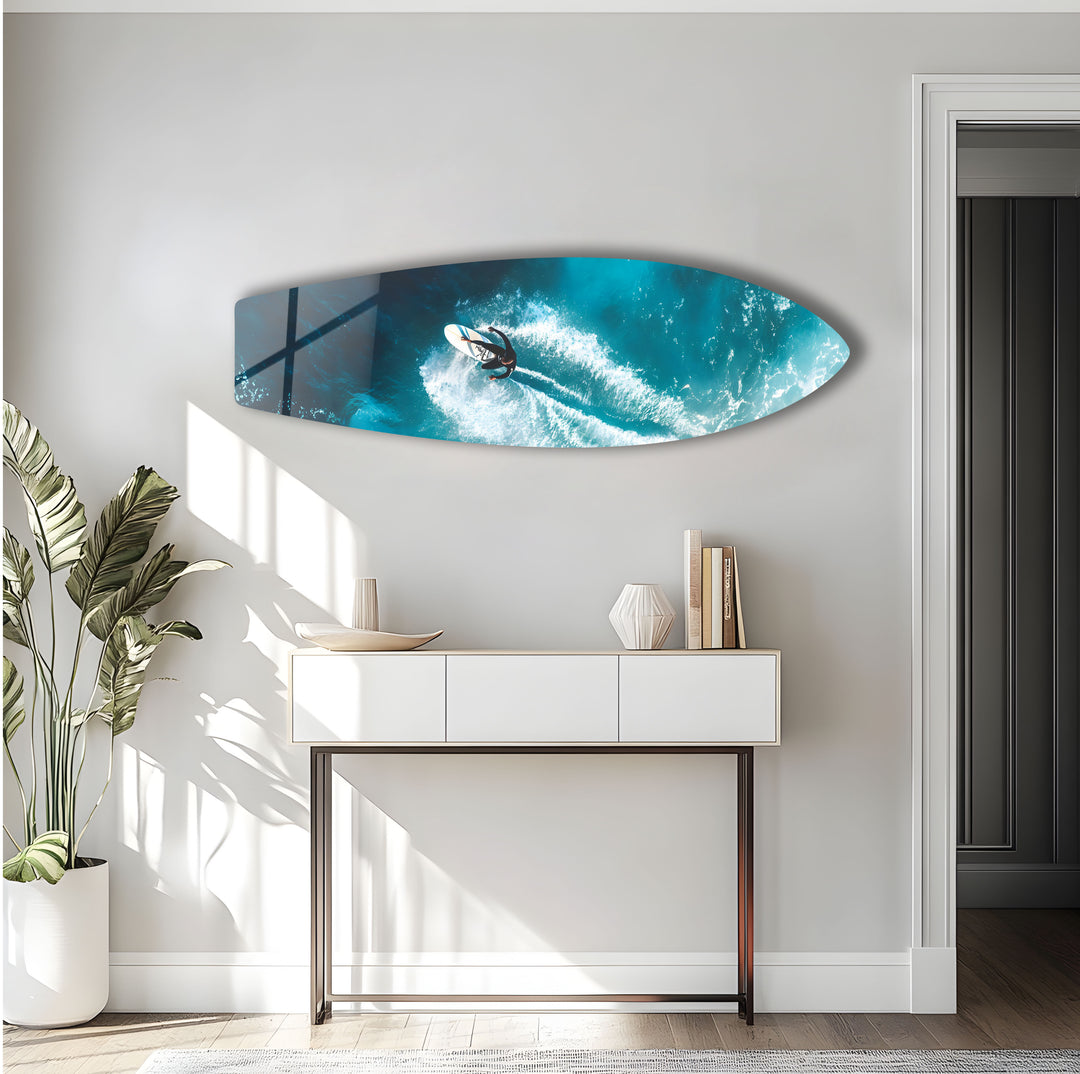 Surf-inspired glass wall art featuring a surfer riding waves in vibrant blues and whites.
