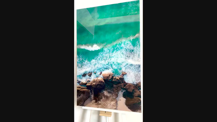 Blue Water With Some Rocks Glass Wall Art