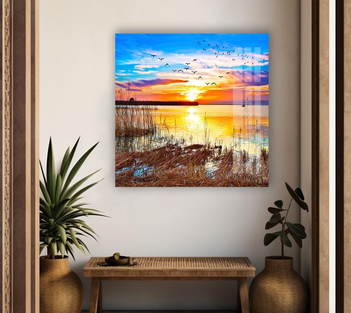 Sunset Over a Lake With Grass Glass Wall Art