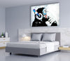 Banksy Dj Monkey Glass Wall Art a bedroom with a bed and a painting on the wall