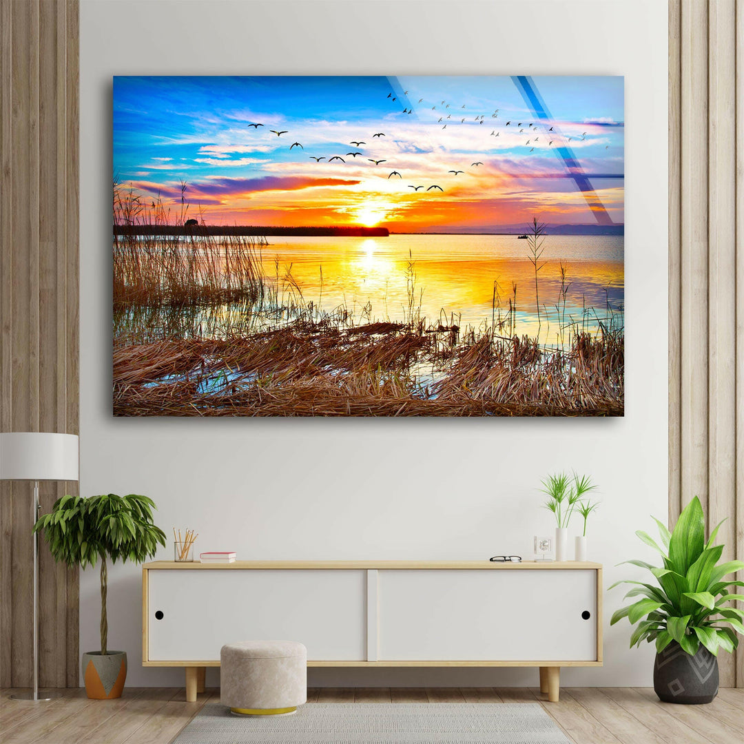 Sunset Over a Lake With Grass Glass Wall Art